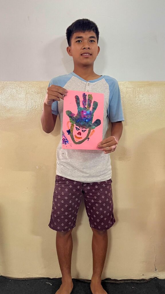 Boy showing his fingerpainting creation