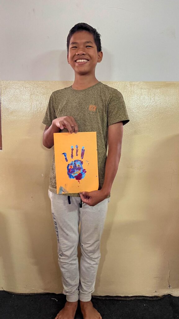 Boy showing his fingerpainting creation