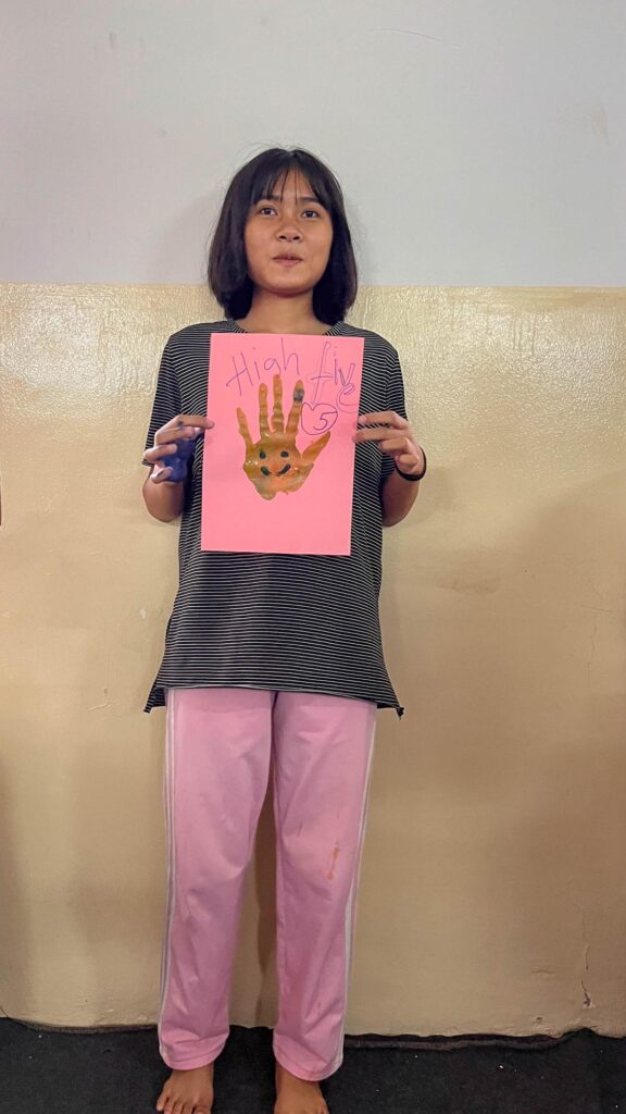 Girl showing her fingerpainting creation