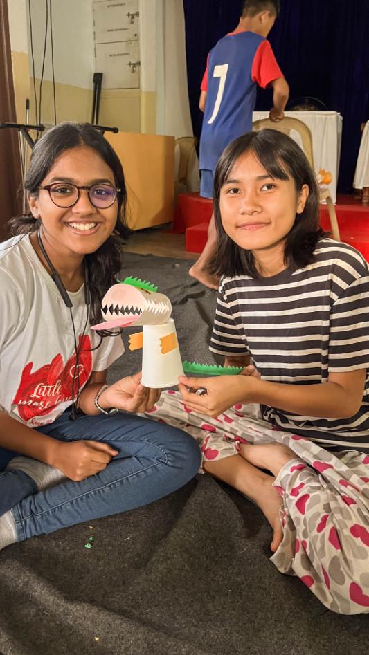 LML volunteer and a Lions Hope Home kid holding their paper creation