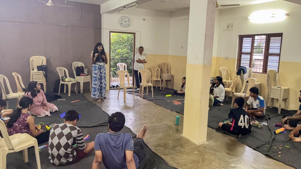 LML volunteer teaching kids how to make paper springs.